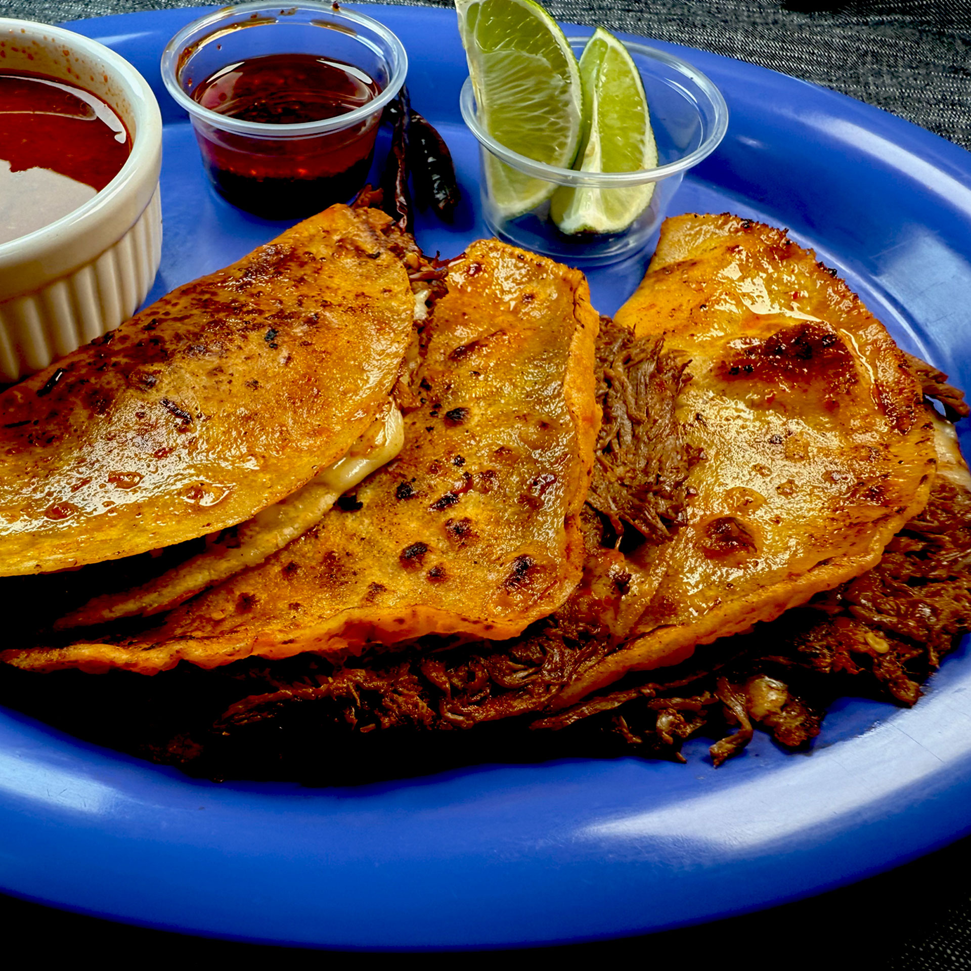 Indulge in our 3 Quesabirrias with Consomé, a cheesy, crispy delight packed with spice-infused beef and griddled to golden perfection. Served with a rich, flavorful consomé for dipping, these quesabirrias melt in your mouth with every bite. Handed down through our family, this dish is a true taste of Mexican tradition. Dip into deliciousness! #Quesabirria #ConsoméMagic #MexicanCuisine #FamilyTradition #FoodieHeaven